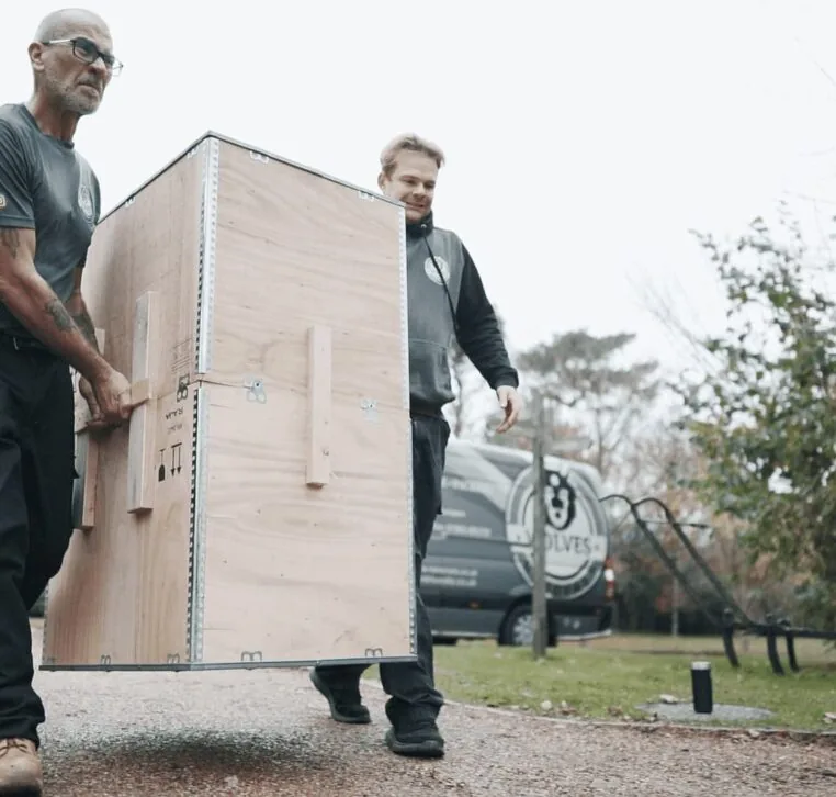 Two Wolves Storage Sussex movers carrying a wooden storage container to the van — Wolves Storage Sussex serving Henfield
