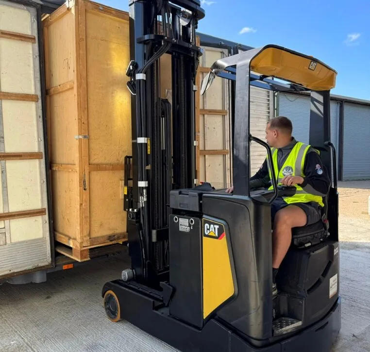 Wolves Storage Sussex operator loading a sealed wooden storage container with a CAT forklift at our Ashington warehouse