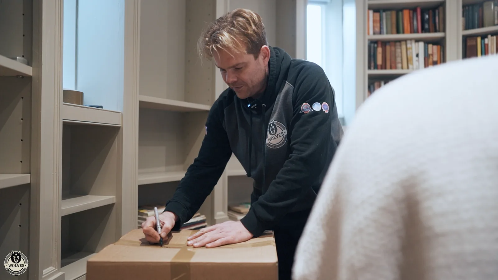 A Wolves team member labelling a carefully packed box of books — Wolves Storage Sussex serving Lancing