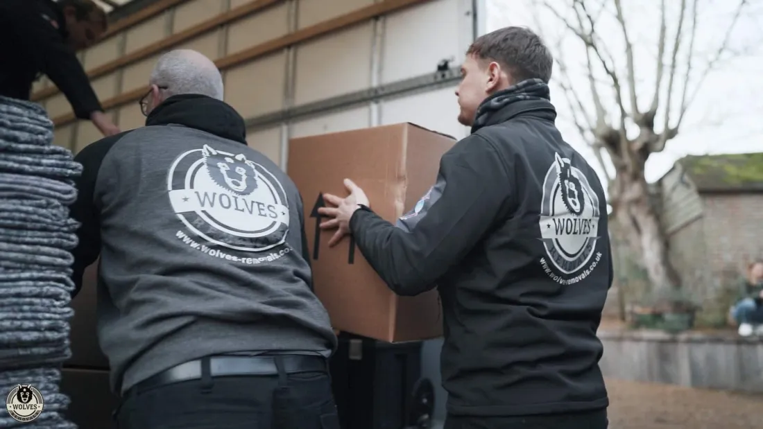 The Wolves team carefully carrying a wrapped box out to the van for storage &mdash; Wolves Storage Sussex serving Midhurst