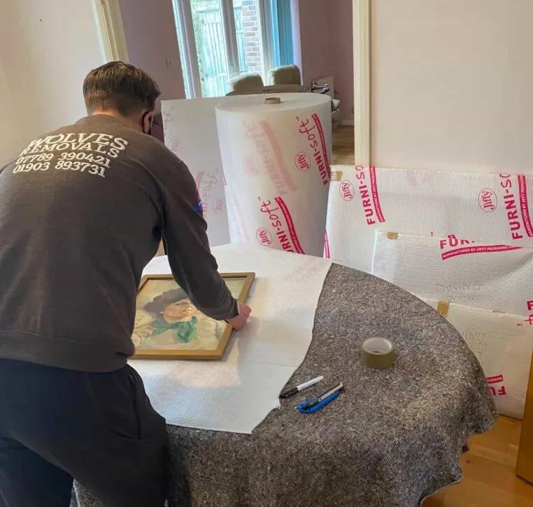 A Wolves Storage Sussex packer wrapping a framed picture in Furni-soft padding &mdash; Wolves Storage Sussex serving Arundel